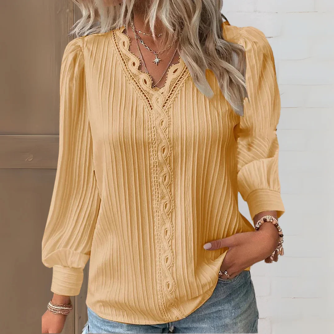Gelbe Damenbluse mit V-Ausschnitt, romantischen Spitzendetails und weichem Baumwollmaterial für einen eleganten Look.