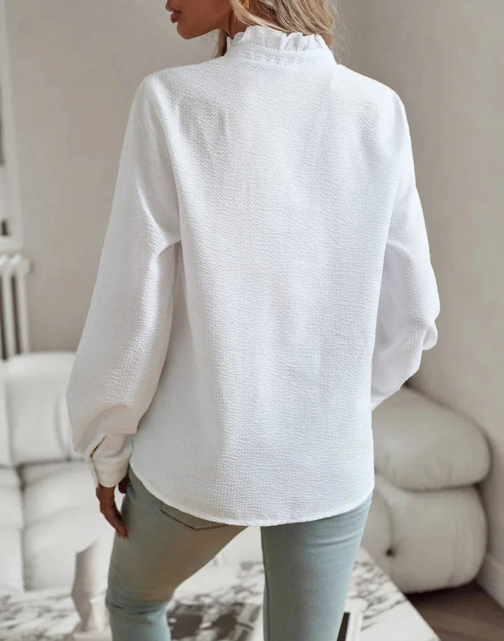Damenbluse mit Rüschenkragen, langen Ärmeln, aus leichtem Baumwollmaterial in elegantem Design.