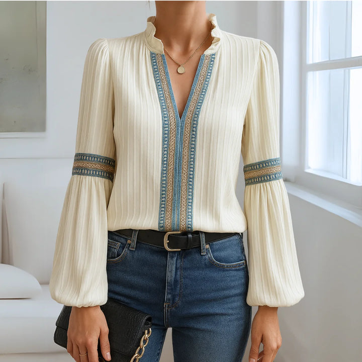 Damenbluse mit V-Ausschnitt, aus leichtem Baumwollstoff, verziert mit eleganten Spitzenakzenten an den Ärmeln.