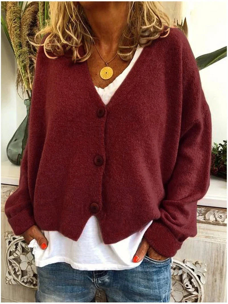 Damenkurzstrickjacke in Kastanienbraun, V-Ausschnitt, Knöpfen und weichem Material für gemütlichen Tragekomfort.