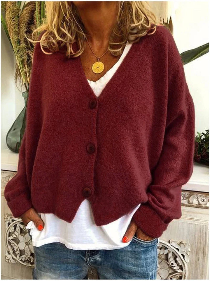 Damenkurzstrickjacke in Kastanienbraun, V-Ausschnitt, Knöpfen und weichem Material für gemütlichen Tragekomfort.