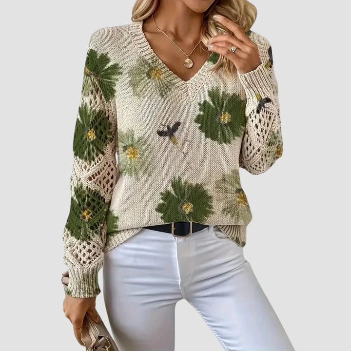 Damenpullover aus weichem Baumwollmix mit buntem Blumenmuster und filigranen Häkel-Details an den Ärmeln.