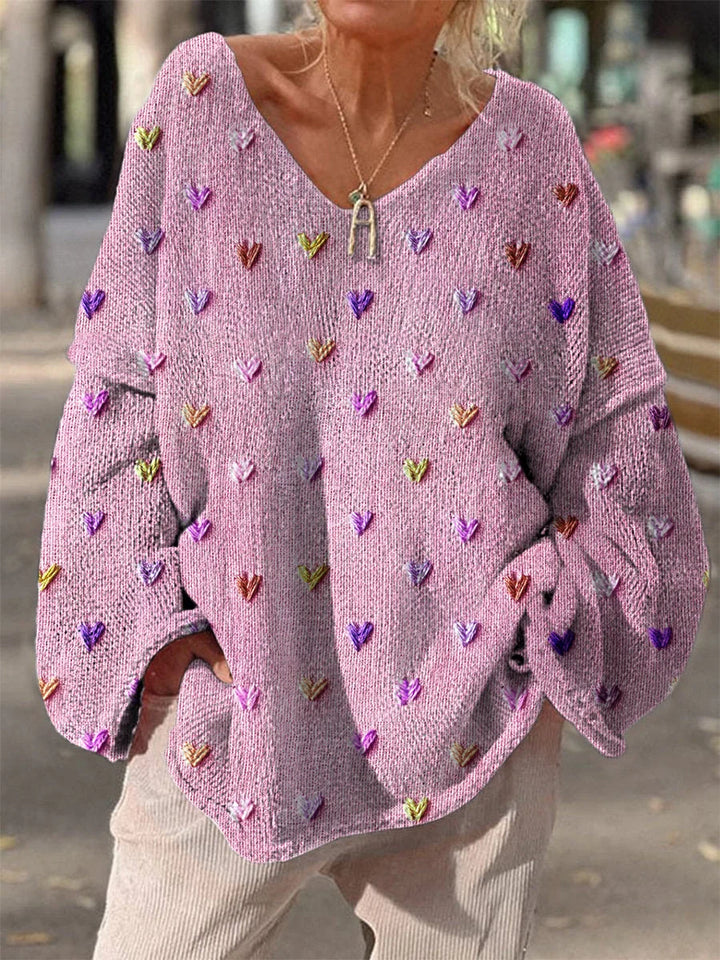 Rosa Damenpullover mit Herzdesign, weichem Material und lockerer Passform für einen lässigen Look.
