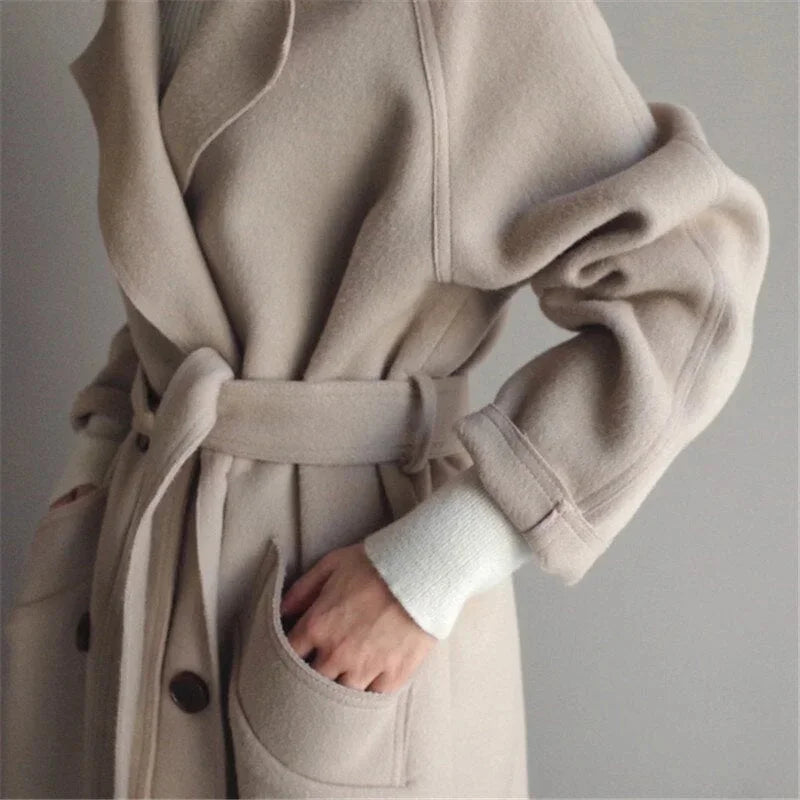 Eleganter, lang geschnittener Damenmantel aus hochwertigem Material mit Gürtel und modischem Kragen für vielseitige Outfits.