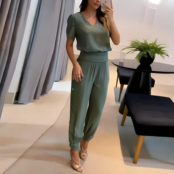 Elegante Damenbluse aus leichtem Stoff in Olivgrün, kombiniert mit gemusterter Hose für einen stilvollen Look.