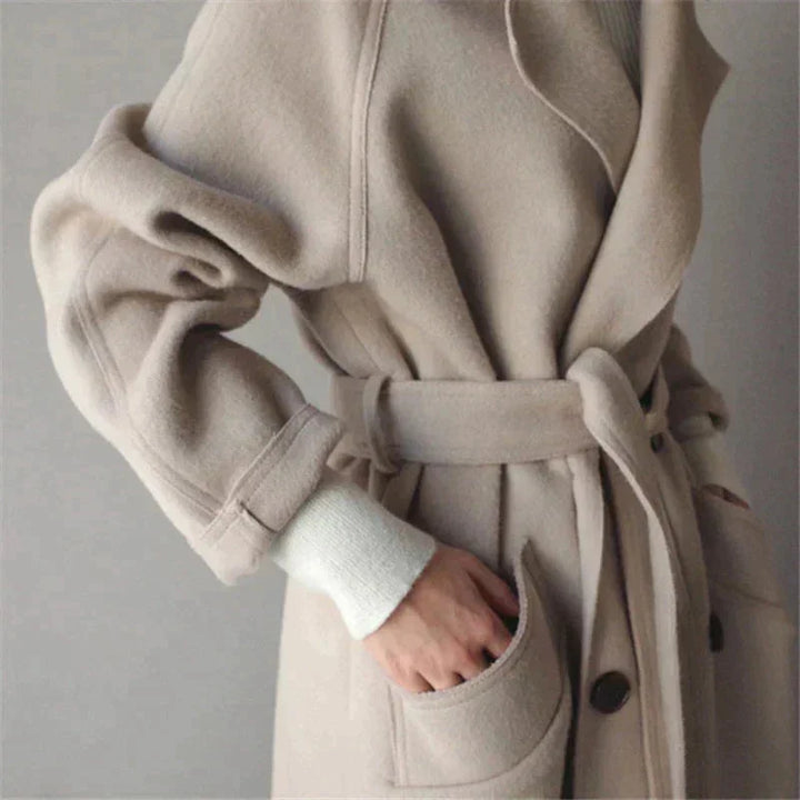 Eleganter Damenmantel aus weichem Stoff mit Gürtel und klassischen Knopfdetails, ideal für Herbst und Winter.