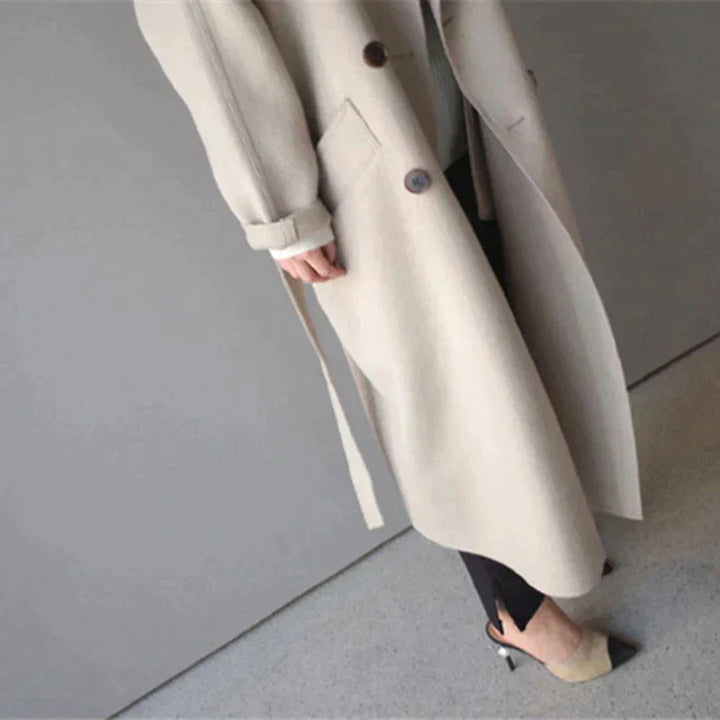 Eleganter Damenmantel aus hochwertigem Stoff mit Gürtel und dekorativen Knopfdetails, ideal für stilvolle Anlässe.