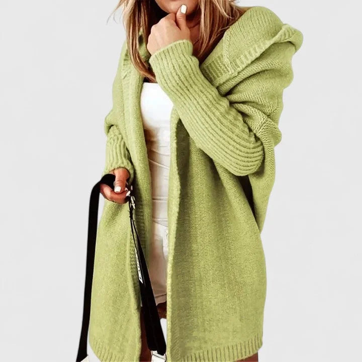 Grüne oversized Damen Strickjacke mit Kapuze aus weichem Strickmaterial und lässigem, offenen Design.