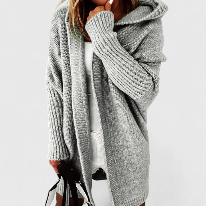 Graue oversized Damen Strickjacke mit Kapuze, aus weichem Material, ideal für lässige Outfits und kühle Tage.